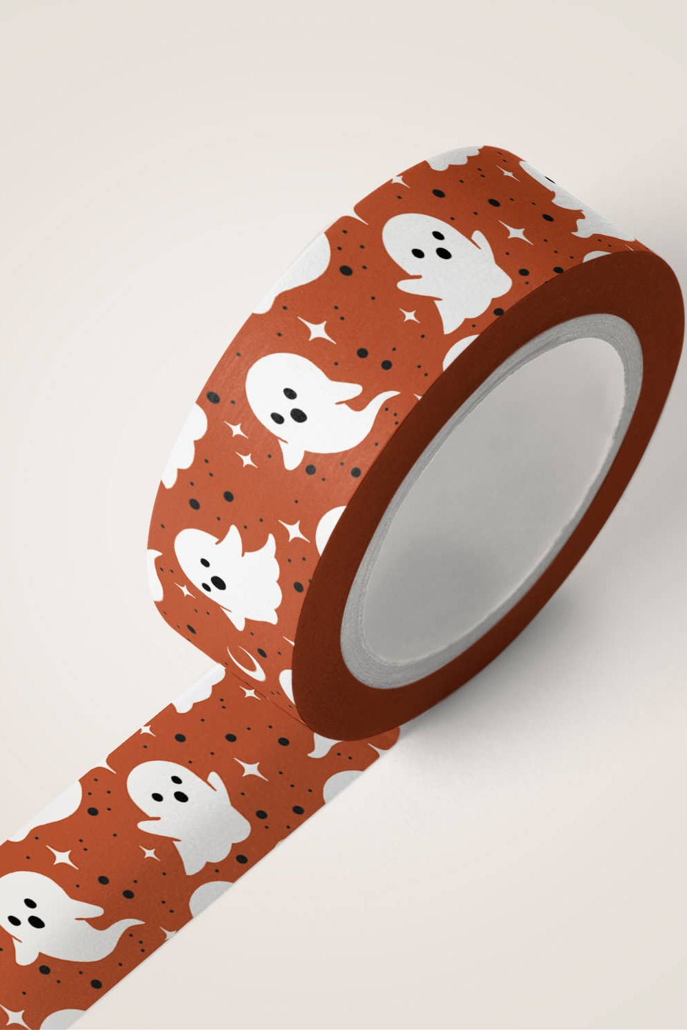 Roll of decorative tape with ghost pattern on a beige background