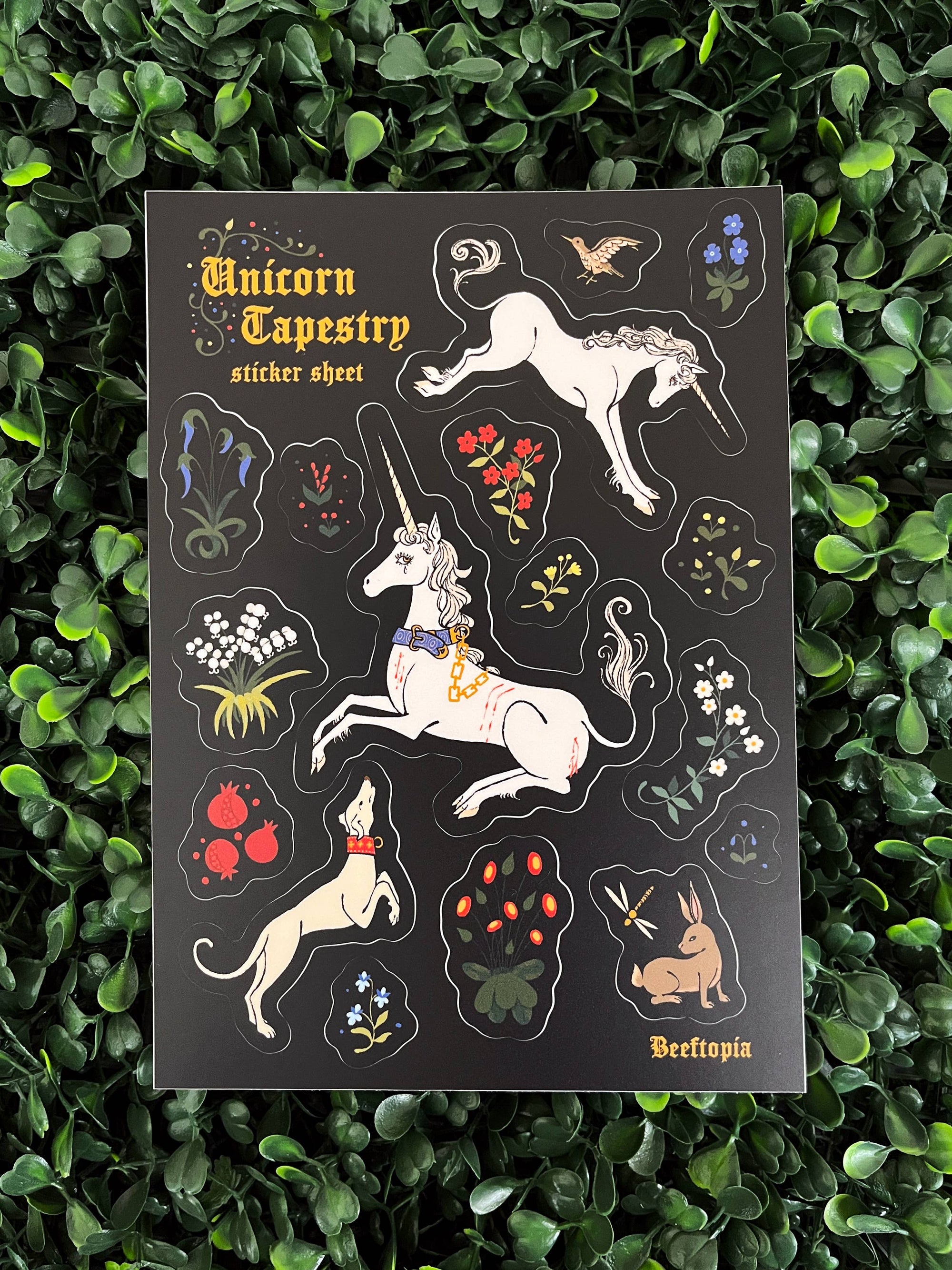Unicorn-themed tapestry sticker sheet on a green leafy background