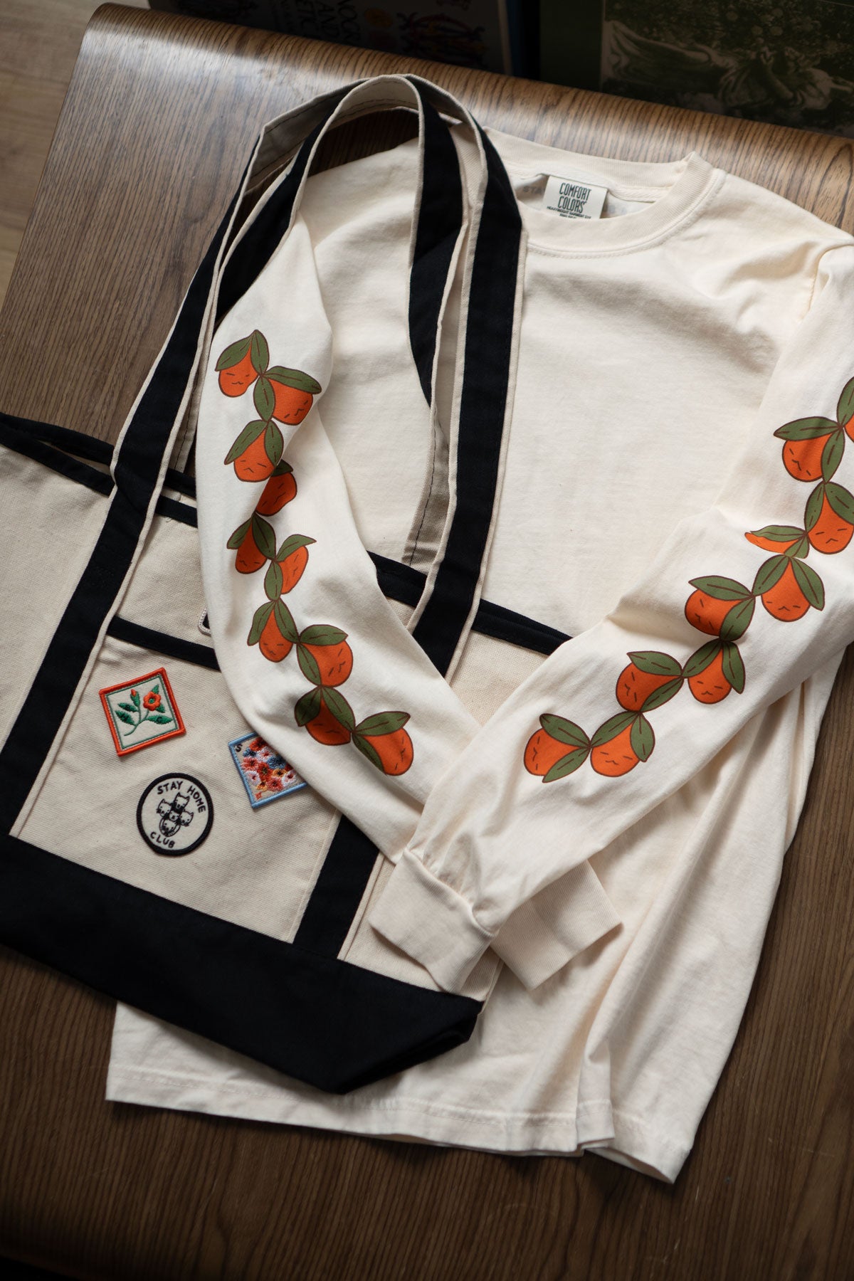 Off-white long sleeved t-shirt with cute oranges printed down the sleeves