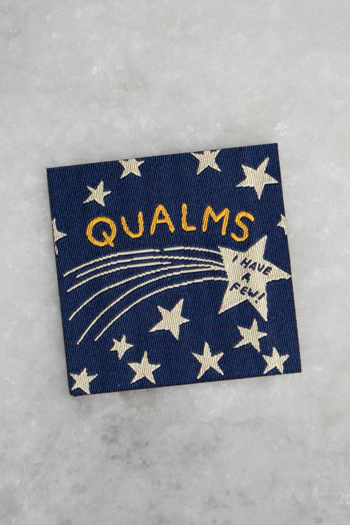Navy blue patch featuring a star design and the text "Qualms - I have a few!"