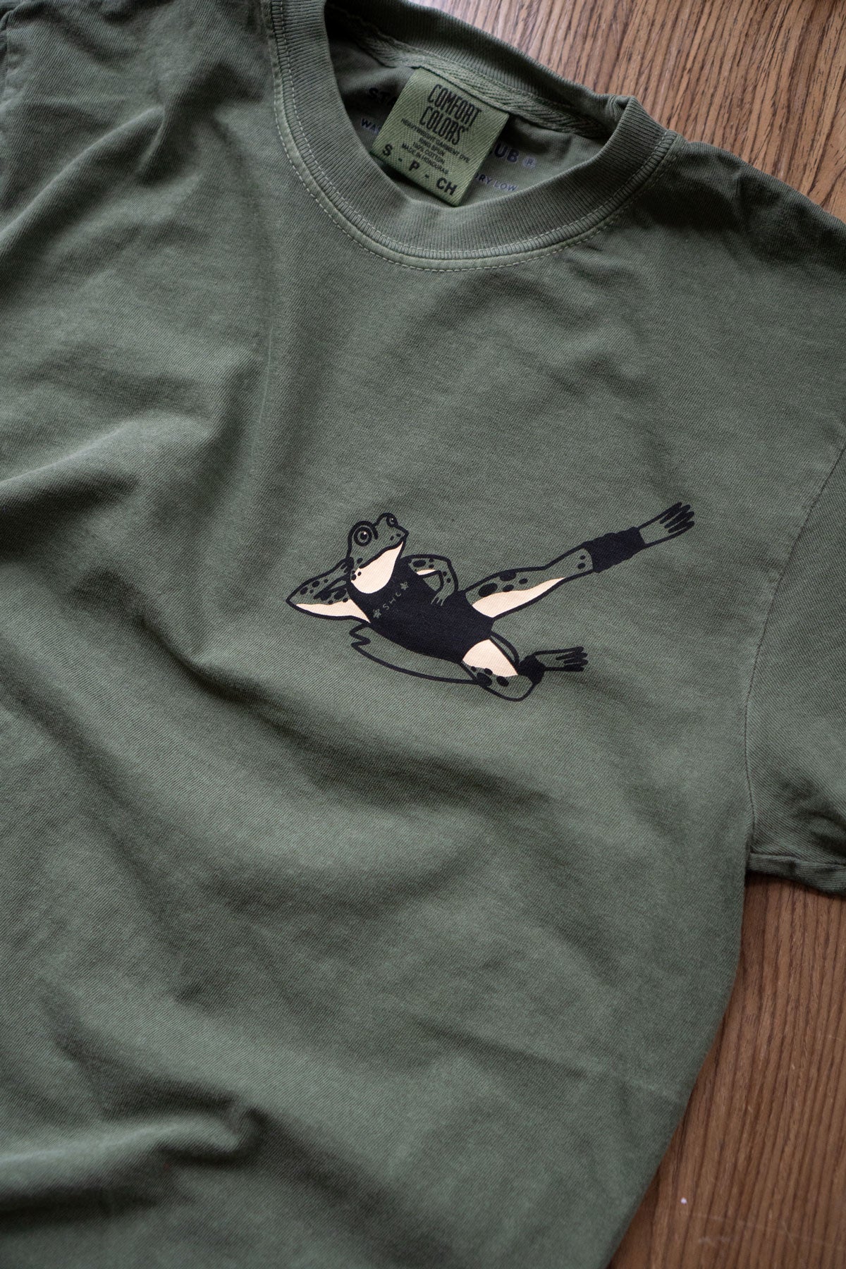 T-shirt print featuring a frog exercising in '80s workout gear